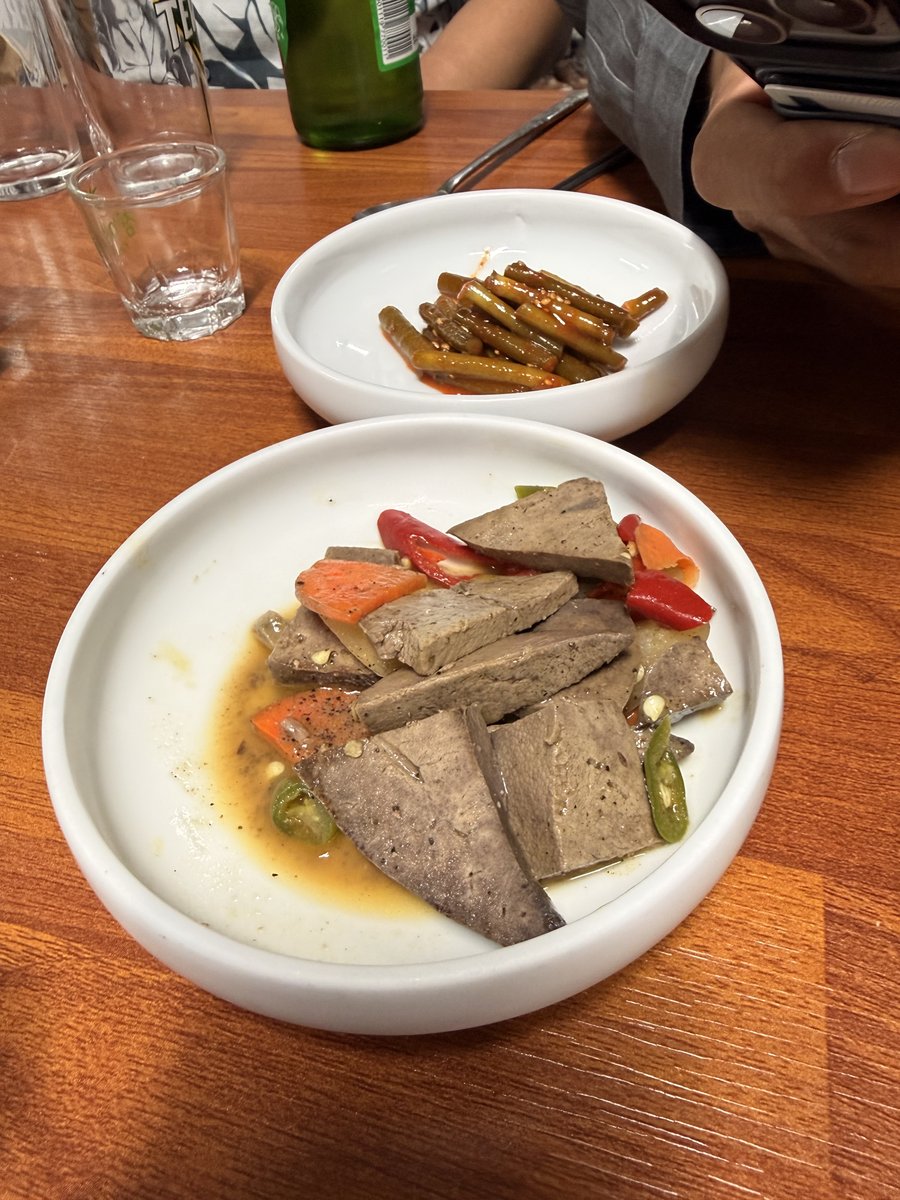 정갈한 마늘종 장아찌와 따뜻하게 삶아낸 돼지 간 서비스 밑반찬 2026
