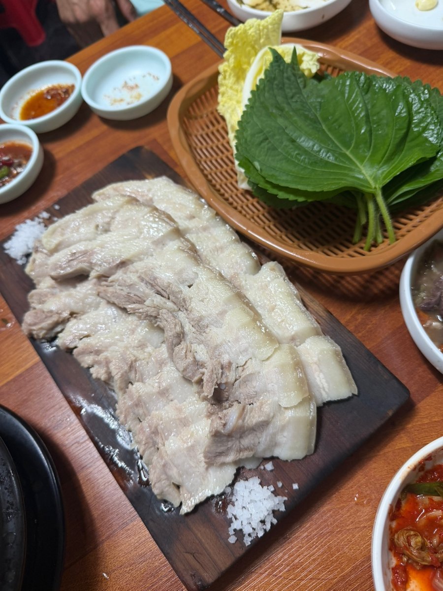 나무 도마 위 굵은소금과 함께 세팅된 제주 갓 삶은 돔베고기 오겹살 수육 2026